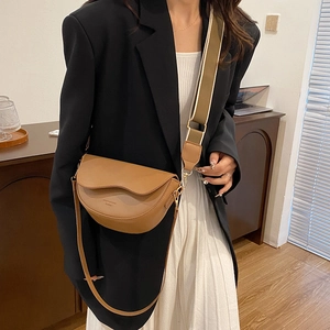Minimalist brown saddle shoulder bag with wide woven strap and smooth PU leather finish