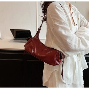 Detail of dark red glossy PU leather shoulder bag with sleek minimalist French style