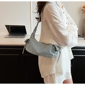 Detailansicht der hellblauen Denim-Hobo-Tasche mit seitlichem Kordelzug im Alltagsszenario