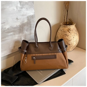 Detail of vintage tote bag featuring canvas leather patchwork and metal hook hardware