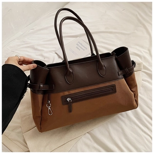 Detail of vintage tote bag featuring dual-tone canvas and leather with front zip pocket