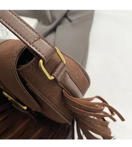 Detailed macro view of retro brown tassel crossbody bag with premium gold hardware finish
