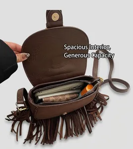 Close-up of the spacious main compartment and interior pocket of a brown tassel saddle bag