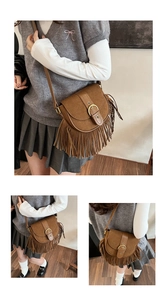 Macro detail of vintage saddle bag with brown matte texture and long fringe accents