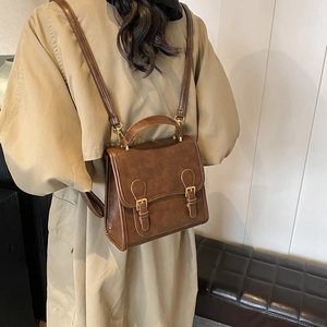 Retro brown leather backpack with buckle straps for women in a vintage academic style