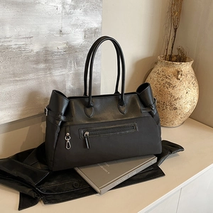 Classic black leather and canvas patchwork tote bag with zipper pocket and metal hook details