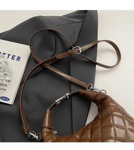 Close-up of adjustable strap and silver metal buckle on quilted brown leather bag
