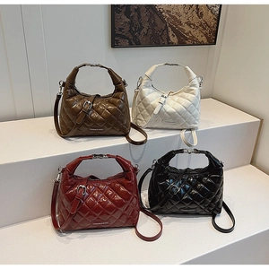 Close-up of quilted patent leather bags with metallic handles in four various colors
