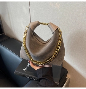 Détail du sac Hobo en daim gris foncé avec chaîne dorée et poignée en cuir lisse