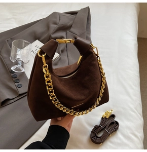 Détail du sac à main en daim marron foncé avec chaîne dorée et bandoulière