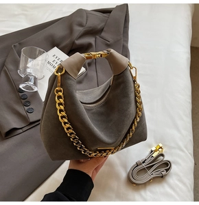 Détail du sac hobo en daim taupe avec grosse chaîne dorée et bandoulière réglable