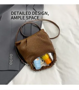 Detail view of brown pleated tote bag showing spacious interior with phone and cosmetics