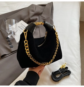 Détail du sac en daim noir mat avec poignée en chaîne dorée épaisse et bordure en cuir
