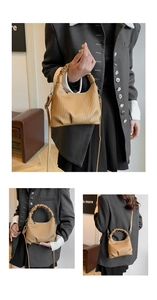 Detail view of khaki brown pleated handbag with ruched handle and detachable strap
