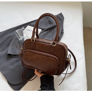 Detailed view of dark brown vintage faux leather tote bag with brushed gold zippers