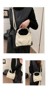 Detail showing creamy white pleated texture and cloud-style handle of the shoulder bag