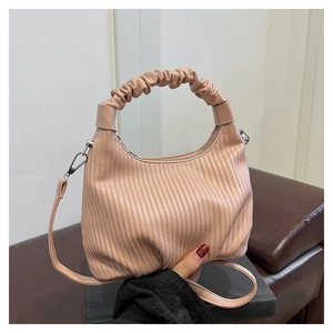 Detail of light pink pleated cloud bag featuring scrunchie handle and silver zipper