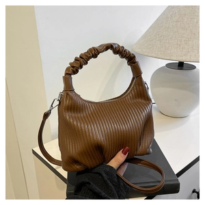 Detail of brown pleated texture bag with scrunched handle on a vintage book