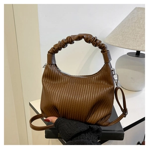 Detailed view of dark caramel ruched handbag with scrunchie handle and silver zipper