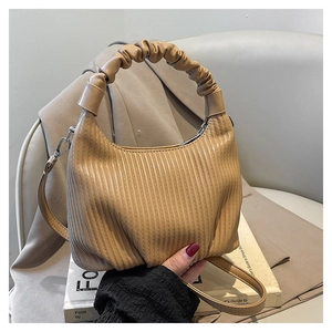Detail of apricot pleated handbag with scrunchie handle and adjustable shoulder strap