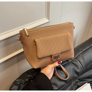 Close-up of khaki corduroy crossbody bag featuring a vertical texture and gold metal lock