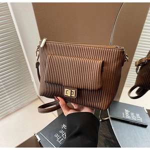 Detailed close-up of brown pleated shoulder bag with golden metal lock and leather texture