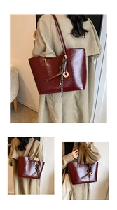 Dettaglio della grande borsa tote bordeaux con trama in pelle lucida e ciondolo a nappe