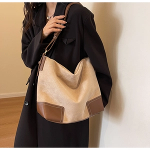Detailed shot of large faux suede tote bag featuring contrast leather stitching and soft texture