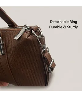 Detail of brown embossed textured handbag showing silver hardware and detachable strap