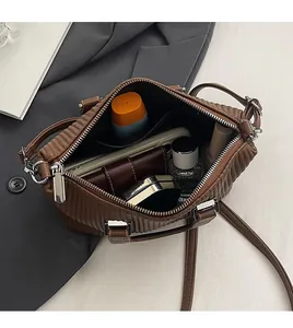 Interior view of brown quilted bag showing large capacity for phone and wallet