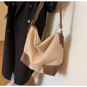 Detail of suede tote bag with contrast leather stitching and large capacity design
