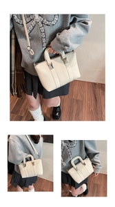 Detail view of cream-white striped PU leather handbag with silver buckles and strap