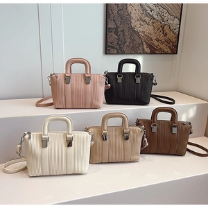 Detail showing various colors of pleated tote bags with adjustable shoulder straps