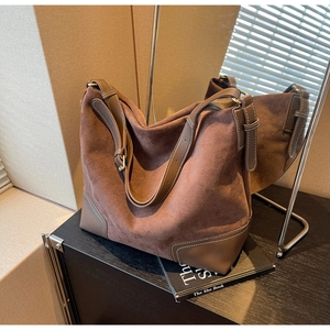 Detail of suede tote bag showing contrast stitching and premium leather trim finish