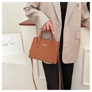 Detailed view of brown quilted PU leather handbag with gold JINGPIN logo and handle