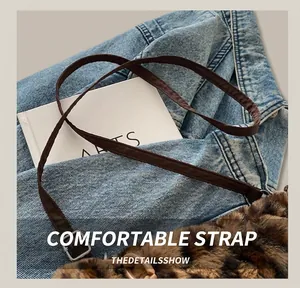 Détail d'un sac en peluche léopard avec bandoulière marron et boucle en métal argenté