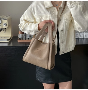 Detail of khaki bucket bag with pebbled leather texture and embossed fashion text