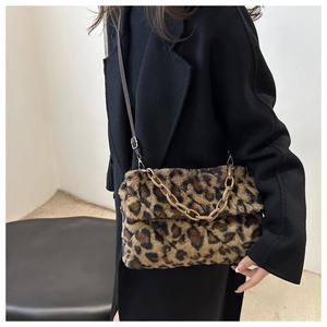Détail d'un sac d'épaule en peluche léopard avec chaîne dorée et bandoulière cuir