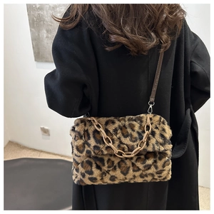 Détail du sac à bandoulière en fausse fourrure léopard avec chaîne sur manteau noir