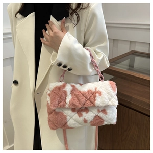 Détail du sac en peluche à motif vache rose avec chaîne acrylique et texture matelassée