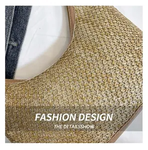 Gros plan du sac fourre-tout en paille tissée avec bordure en cuir marron et fermeture