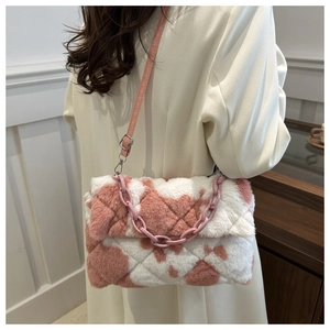 Gros plan sur la texture douce du sac à bandoulière en peluche rose et blanc à motif