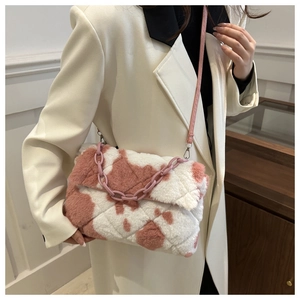 Dettaglio borsa in ecopelliccia con catena acrilica rosa indossata su cappotto beige