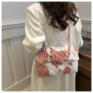 Détail d'un sac porté épaule en peluche rose et blanc avec matelassage et chaîne