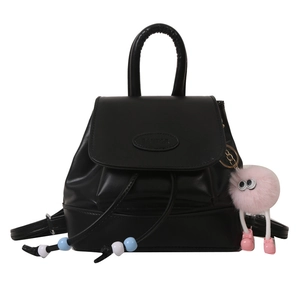 Minimalist black faux leather backpack with drawstring and pink plush charm