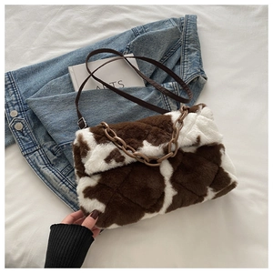 Détail du sac en peluche à motif vache avec surpiqûres losanges et chaîne épaisse