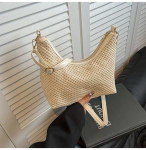 Détail du sac demi-lune tressé crème avec ferrures dorées et bandoulière en cuir réglable