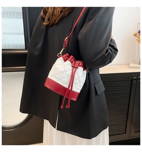 Detail of red and white quilted bucket bag with drawstring closure on a model