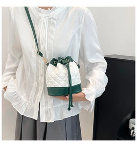 Detail of the green quilted bucket bag with drawstring closure and chain strap