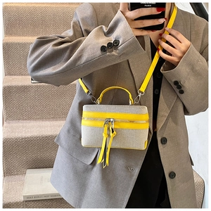 Vue détaillée d'un mini sac vanity en toile grise avec finitions et bandoulière jaunes